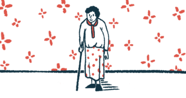 An elderly woman leans on a cane in a wallpapered room.