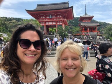 Two women take a selfie in front of one of Kyoto, Japan's many iconic temples.