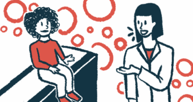 A child in a red shirt sits on an examination table and listens to a doctor in a white lab coat.