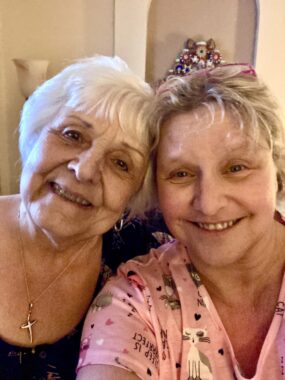 A close-up selfie of a mother and daughter smiling. 